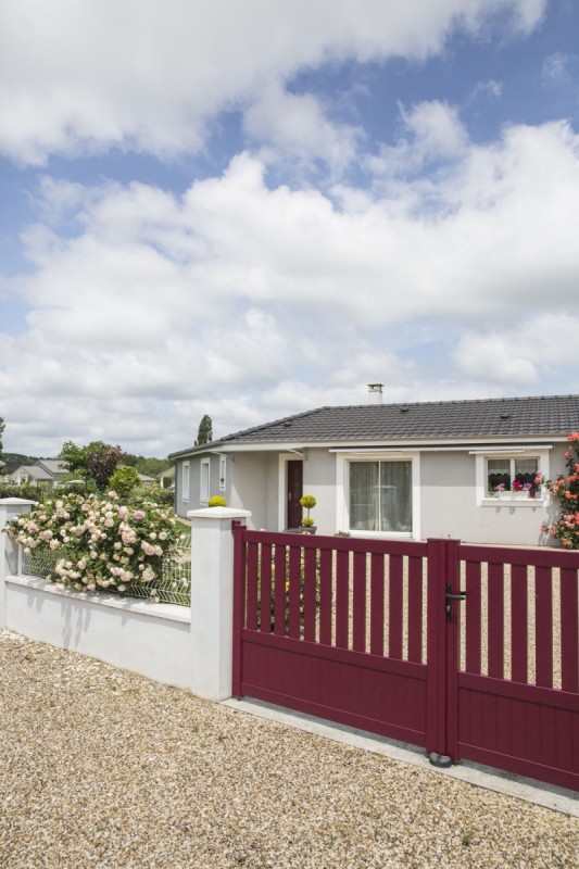 Maison de plain-pied vue de l’’extérieur avec un portail rouge