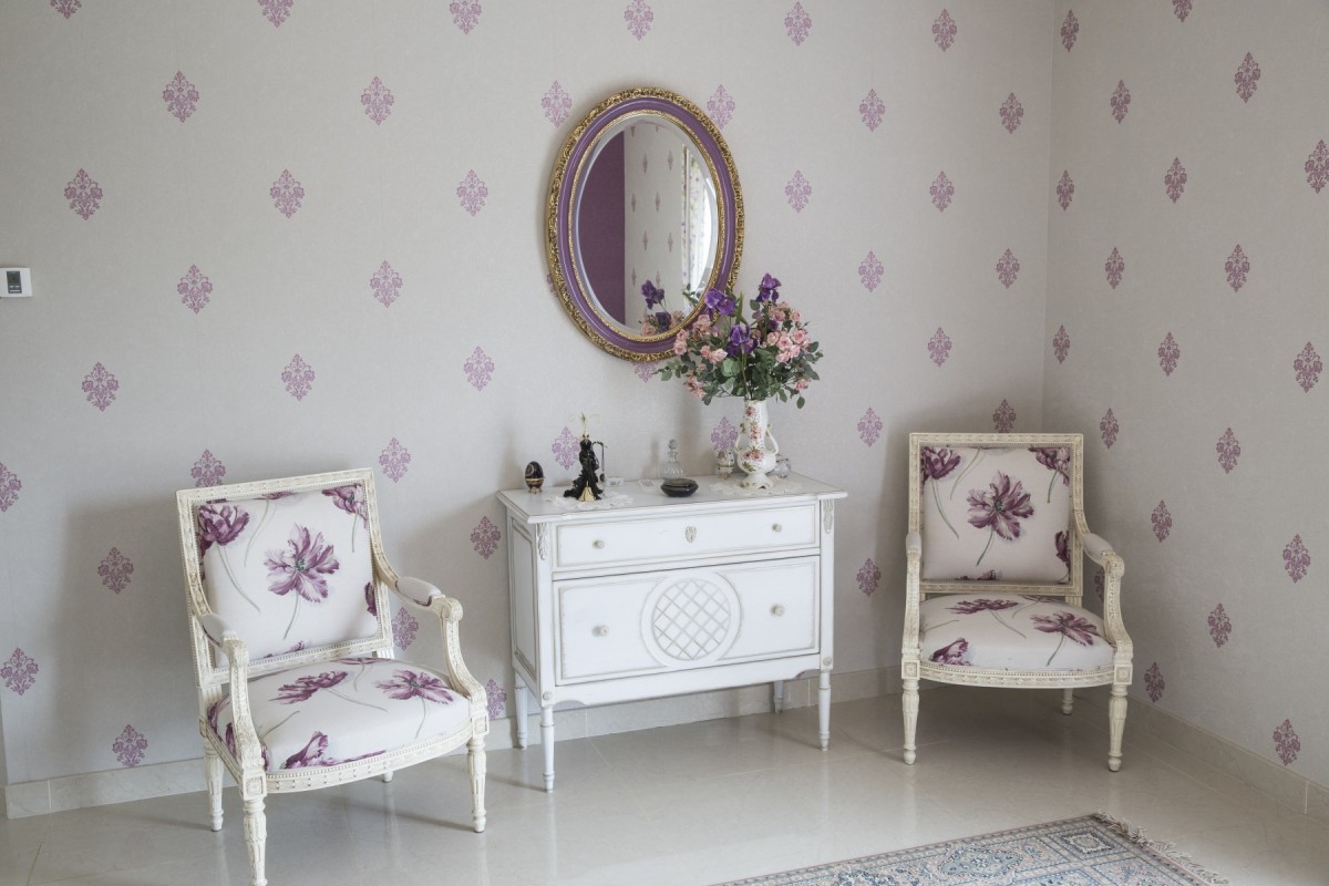 Maison périgourdine, vue intérieure avec son espace détente composé de deux fauteuils et d’une coiffeuse au milieu d’un décor traditionnel