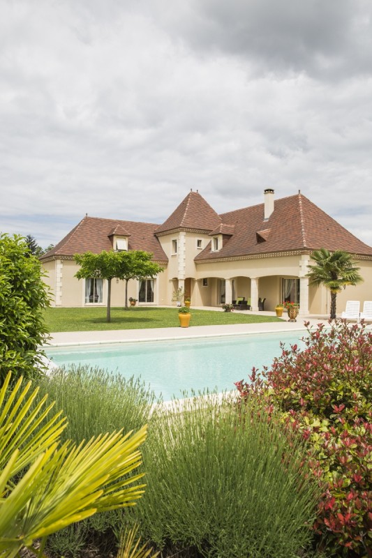 Maison périgourdine vue d’extérieur avec une piscine parfaitement intégrée au paysage de Dordogne