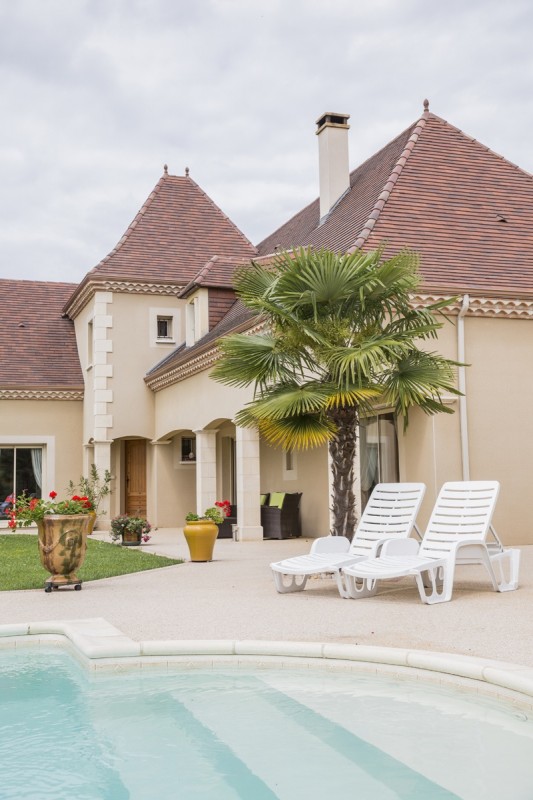 Maison périgourdine montrant la piscine ainsi que le coin jardin et l’aménagement extérieur