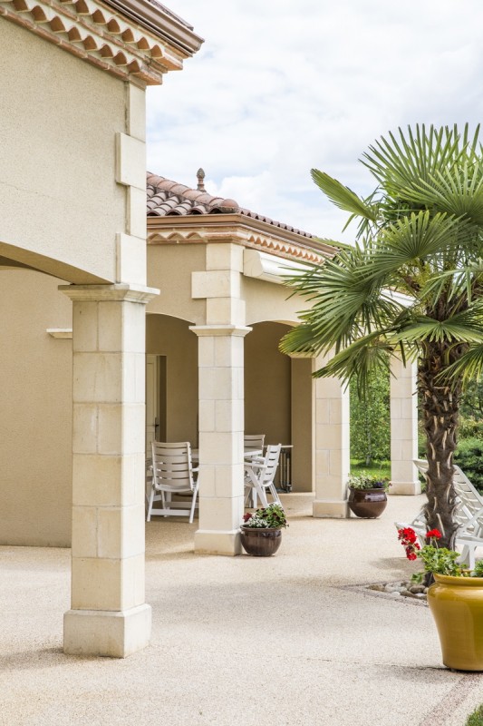 Maison périgourdine vue d’extérieur montrant l’aménagement de la terrasse avec ses imposants piliers extérieurs en marbre