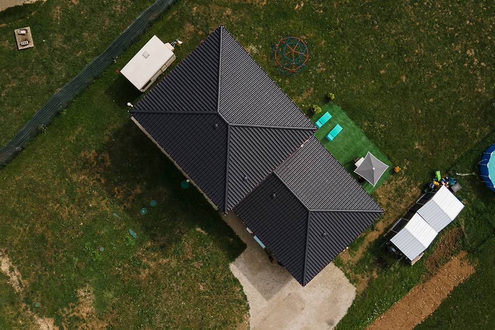 Maison moderne avec tuiles noires sur un grand terrain