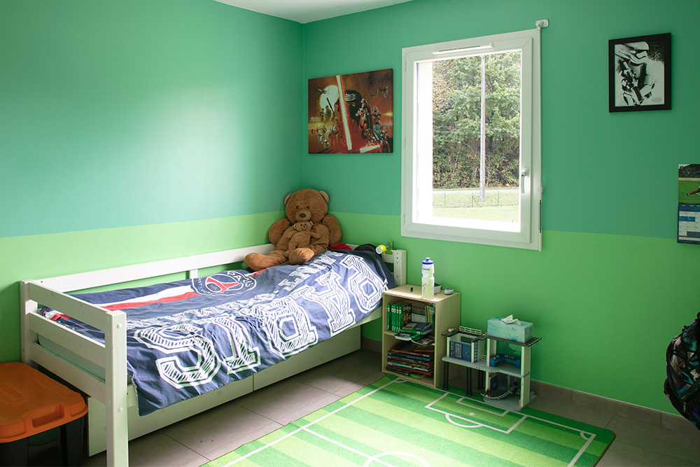 Chambre d'enfants avec grosse peluche et vue sur jardin