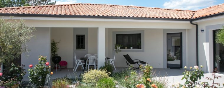 Entrée d'une maison fleurie avec végétation