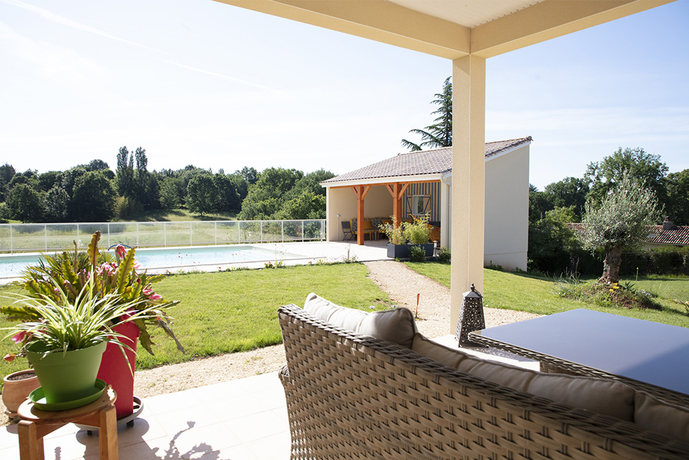 Vue sur une piscine et un pool-house en Dordogne