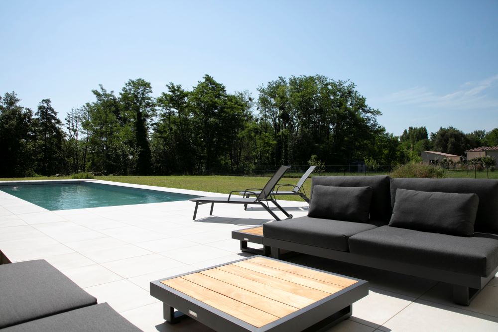 Terrasse ensoleillée avec salon de jardin et piscine