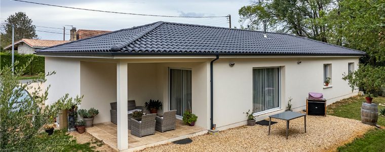 Maison traditionnelle avec terrasse couverte et tuiles noires