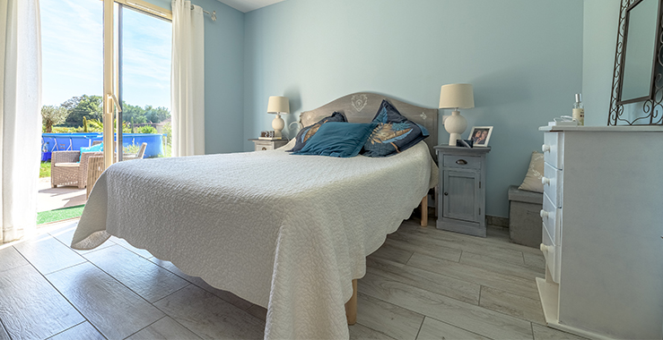 Chambre avec grand lit et ouverture vers la terrasse